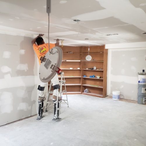 A person installing drywall